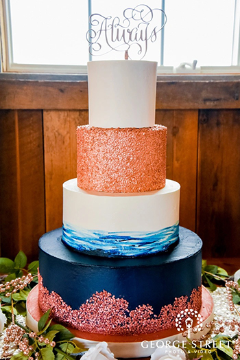 4 Tier navy blue and ivory buttercream wedding cake, decorated with edible rose gold sequins delivered at Wyndridge Farm in Dallastown PA