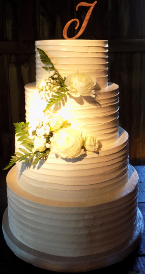 4 Tier rustic buttercream wedding cake decorated with fresh flowers