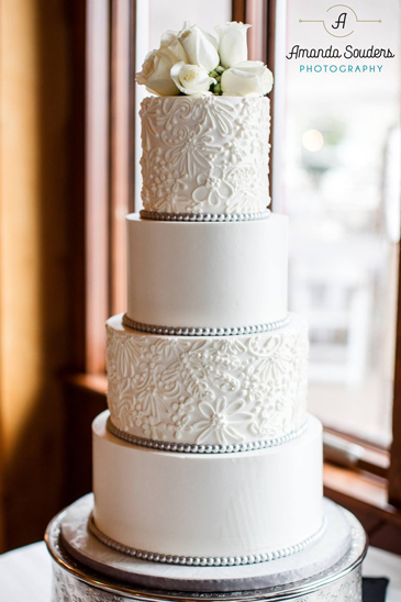4 Tier buttercream wedding cake, decorated with buttercream lace, silver fondant pearls and fresh flowers, delivered at The Lodge at Liberty Forge Mechanicsburg PA
