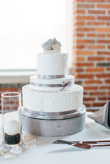 3 Tier buttercream wedding cake, deocrated with buttercream lace, edible silver sugar pearls and silver ribbons and bow delivered at The John Wright Restaurant, Wrightsville PA