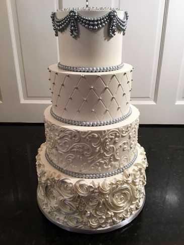 4 Tier buttercream wedding cake, decorated with silver fondant pearl swags, buttercream quilt design with silver edible pearls, buttercream scrolls and rosettes and fondant pearl borders delivered at Cameron Estate Inn Mt Joy PA