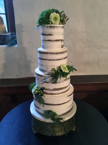 4 Tier semi naked wedding cake, decorated with fresh greenery and flowers delivered at The Stone Mill Inn Hellam PA