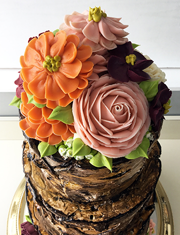 Top view of 4 tier rustic buttercream tree stump cake decorated with buttercream flowers