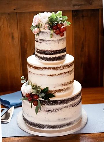 3 Tier semi naked wedding cake decorated with fresh flowers, greenery and grapes delivered to Wyndridge Farm Dallasown PA