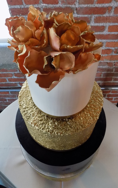 Top view of 3 tier ivory, gold and navy blue buttercream wedding cake decorated with edible gold sequins and sugar flowers. Wedding Cakes John Wrights restaurant York PA
