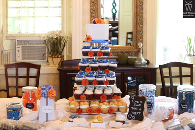 Small wedding cutting cake, decorated with royal blue and orange sugar flowers and cupcakes decorated with an assortment of buttercream flowers delivered at Peter Allen House in Dauphin PA