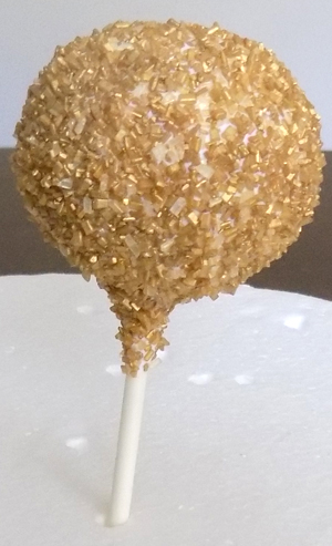 Cake truffles dipped in white chocolate and covered heavily with gold sugar crystals