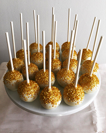 Top view of gold and white cake pops. Vanilla cake pops dipped in white chocolate and decorated with edible gold shimmer.