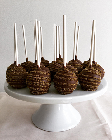 Chocolate cake pops, dipped in milk chocolate and decorated with gold sanding sugar stripes. Milk chocolate cake pops York PA