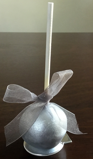 Chocolate cake pops dipped in white chocolate painted in edible silver paint and decorated with silver bows