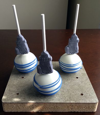 Nautical themed cake pops. Chocolate cake pops dipped in white chocolate, decorated with blue chocolate stripes and silver fondant light houses