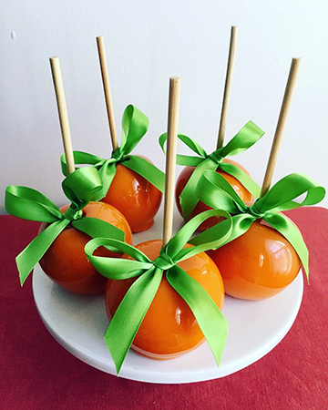 Maple flavored neon orange candied candy apples