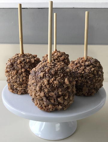 Caramel apples, dipped in milk chocolate and covered in English toffee bits