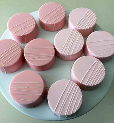 Chocolate Oreos, dipped in blush pink chocolate with white chocolate stripes