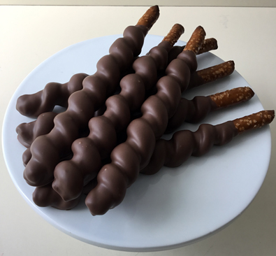 Tall pretzels wrapped in caramel and dipped in milk chocolate
