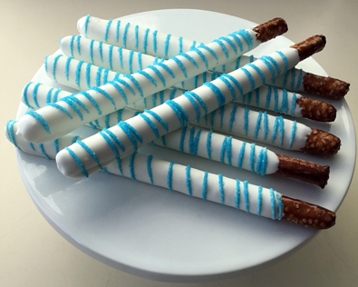 Tall pretzels dipped in white chocolate with light blue sugar crystals
