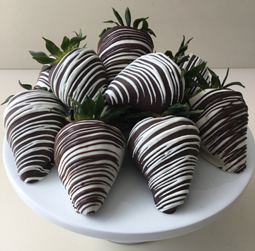 strawberries dipped in dark chocolate with white chocolate stripes and strawberries dipped in white chocolate with dark chocolate stripes