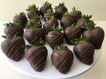 strawberries dipped in dark chocolate with dark criss cross chocolate stripes