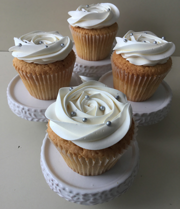 Vanilla cupcakes, topped with buttercream rosettes and decorated with silver sugar pearls