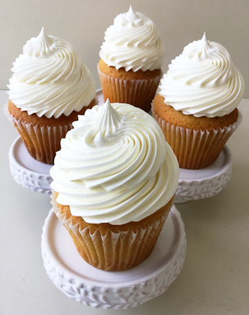 Vanilla cupcakes, topped with swirls of sweet bakery vanilla buttercream using a French star tip