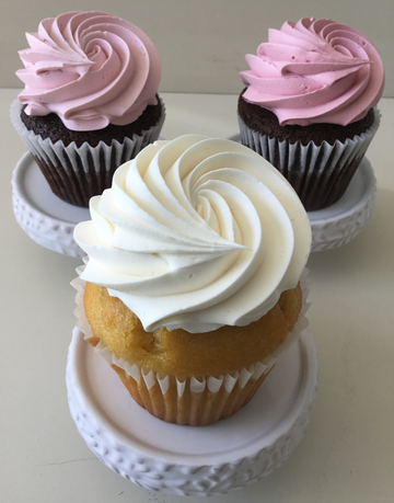 Vanilla and chocolate cupcakes, topped with swirls of white, light pink and pink vanilla vanilla buttercream, using a star tip