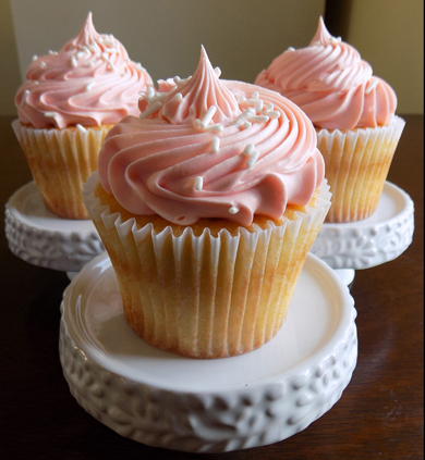 Vanilla cupcakes, filled with cream cheese icing, toped with coral tinted vanilla buttercream