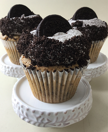 Vanilla cupcakes, topped with Oreo cookies and cream buttercream, with sides covered in crumbled Oreo and topped with Oreo cookies