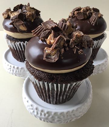 Chocolate cupcakes, topped with peanut buttercream, ganache and peanut butter cup pieces