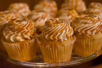 Vanilla cupcakes, topped with swirls of vanilla buttercream and drizzled with caramel sauce