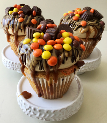 Loaded peanut cupcakes, filled with ganache, topped with peanut buttercream and drizzled with ganache, caramel sauce, peanut sauce, Reese's pieces and peanut butter cups