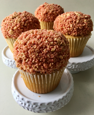 Vanilla cupcakes with a strawberry filling, topped with vanilla buttercream and covered in strawberry crunch