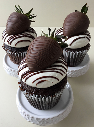 Chocolate cupcakes, with strawberry filling, topped with vanilla buttercream, chocolate ganache drizzle and chocolate dipped strawberries