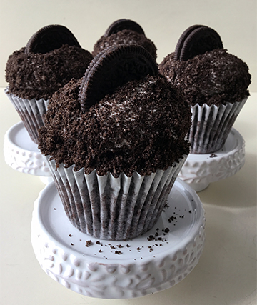 Chocolate cupcakes, topped with vanilla buttercream,  covered in crumbled Oreo and topped with Oreo cookies