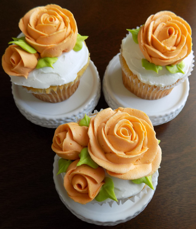 Vanilla cupcakes, filled and iced with vanilla buttercream and decorated with orange buttercream roses delivered at the Peter Allen House in Dauphin PA