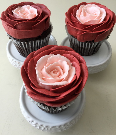 Cupcakes decorated with red and blush buttercream roses