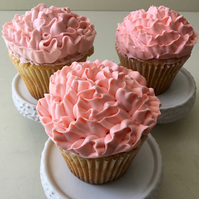 Cupcakes decorated with ruffle coral buttercream flowers