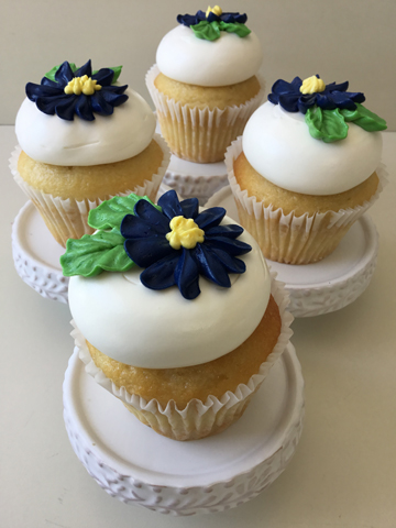Wedding cupcakes, topped with vanilla buttercream and decorated with navy blue buttercream flowers and leaves delivered at Stone Mill Inn in PA