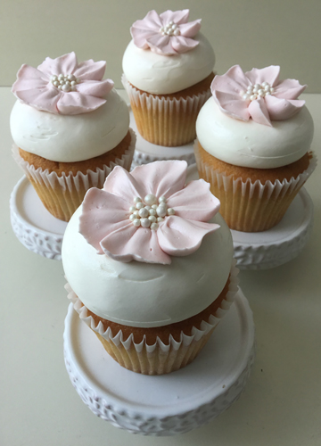 Vanilla cupcakes, topped with vanilla buttercream and decorated with blush buttercream flowers with edible pearl centers