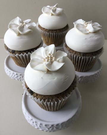 Cookies and cream Oreo cupcakes, topped with vanilla buttercream and decorated with white buttercream blossom flowrs with small edible pearl centers