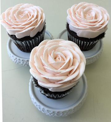 Chocolate cupcakes decorated with light pink buttercream roses