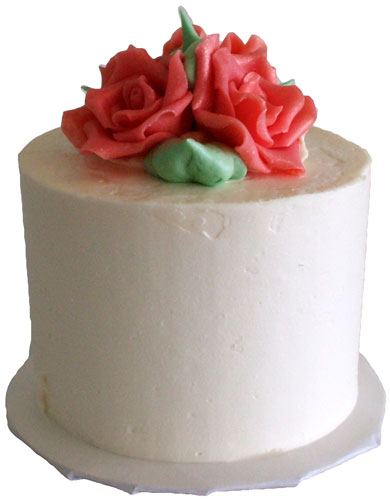2 Inch round mini wedding cake, iced in vanilla buttercream and decorated with chocolate flowers